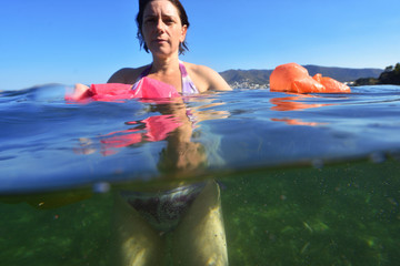 woman bathing in the sea with plastic in the water