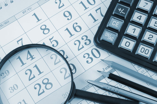 Calculator and magnifying glass on calendar