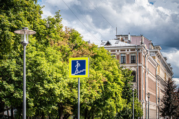 Road sign pedestrian underpass on the background of the cityscape. Street lights, yellow-green...