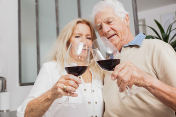 COUPLE SENIOR BUVANT DU VIN ROUGE