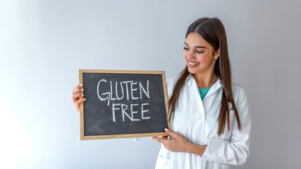 Gluten Free - Physician with chalkboard on grey background. Gluten free food meal allergy healthy eating doctor nurse health with sign. Gluten free food meal allergy healthy eating doctor health 