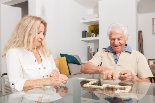 COUPLE SENIOR JOUANT AU JEU DES DOMINOS
