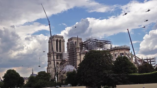 Paris, France - July 11 2019: French military helicopters flying over Notre Dame de Paris during reinforcement work after the fire. This is a preparation fly for Bastille Day Parade.