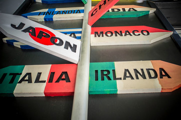 Guidepost with multiple destination countries of the world on arrows sticks in Spanish