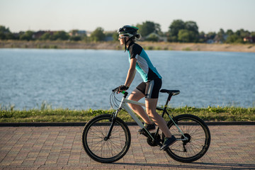 Woman on bike at the lake water background in the park