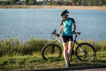 Woman on bike at the lake water background in the park