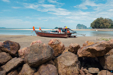 Long Tail Boat and rocks on tropical sand beach, Andaman Sea, in Thailand