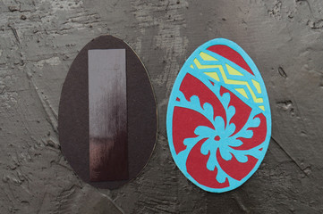Handmade magnets in the shape of Easter eggs on a dark gray concrete background, Ukrainian traditional symbols, copy space, holiday card