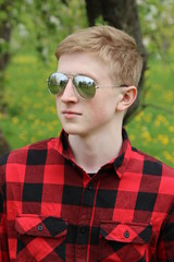 Boy in the red shirt at the city park, summer day, natural lighting.