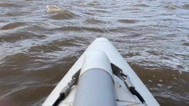Rafting on a catamaran on the Dniester River. The front of the boat can be seen in the frame. The catamaran's nose in the water cuts through the waves.