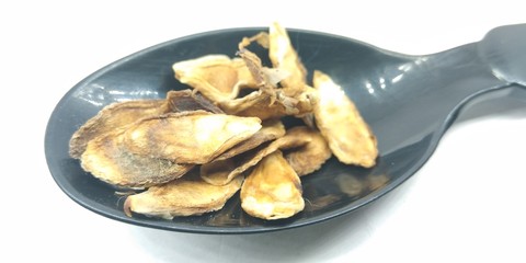 A picture of dry seed's on a black spoon