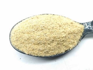 A picture of fenugreek powder on a black spoon