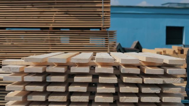 Man folds wooden planks. Stacks of square wood planks for furniture materials. accelerated shooting.