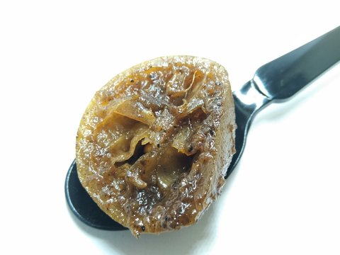 A picture of lemon pickle on black spoon