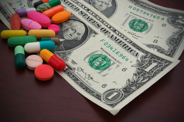 Drugs and dollars on table, cost of drugs concept