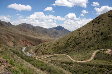The chain of cars on the mountain serpentine near the river between the hills on the pereval 33...