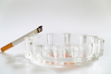 Burnt cigarette on the glass ashtray