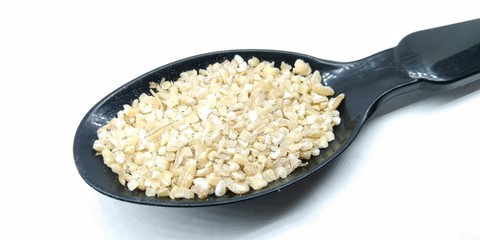 A picture of split wheat on black spoon