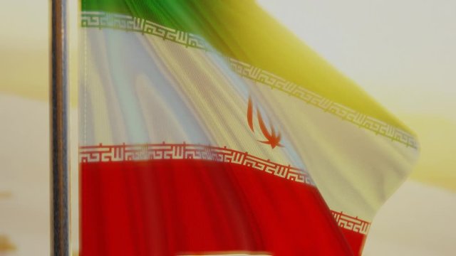 The Iran (Persian) flag waving in the wind at sunset.