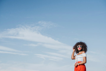 Beautiful afro american woman sticking out tongue in the street