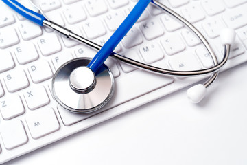 Medical Concept - Stethoscope on computer keyboard on white background. Physician long term care treatment. Close up, macro, copy space
