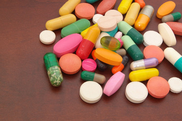 Colorful drugs on wooden table close up
