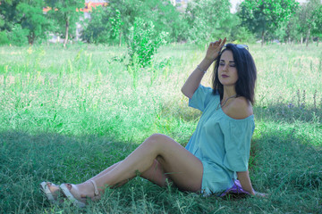Naklejka na ściany i meble Beautiful young brunette woman wearing blue dress, smiling, walking in the park, is happy. Minimalist clothes. Human natural beauty. Trendy casual summer or spring outfit. Street fashion