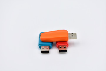 USB flash memory drives with colours, orange, blue and red, on a white background.