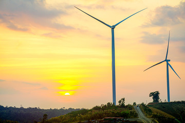 Obraz premium Windmills on the hill with sunset sky, Wind turbine generator to build electricity power in rural area, Electricity power concept