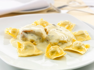 Raviolis rellenos de paté con salsa de queso, comida italiana. Ravioli filled with pate with cheese sauce, Italian food