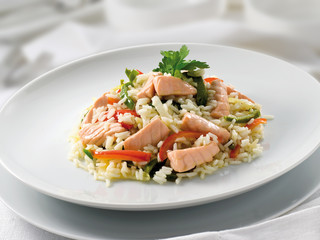 Plato de Arroz con salmón y verduras frescas. Rice dish with salmon and fresh vegetables.