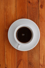 Cup of fresh made coffee on wooden table. Top view.