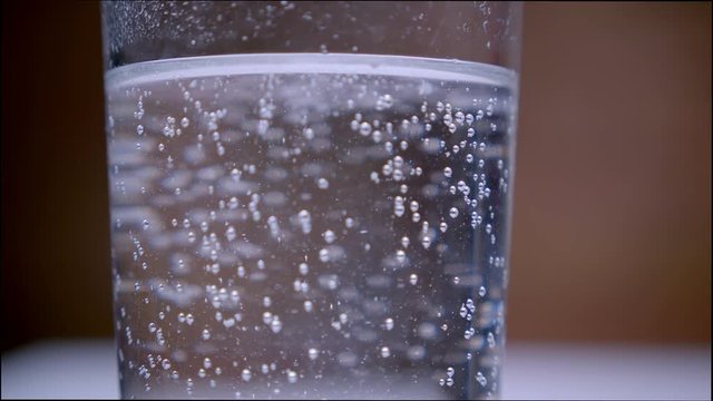 Closeup macro shoot of carbonated water fizzing with bubbles in a transparent glass