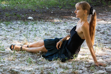 Art photo. Portrait of young seductive woman posing  on the floor with poplar fluff.