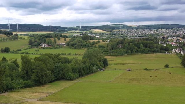 Flight over city Brilon, North Rhine Westphalia, Germany from the north at the ski lift. From east to west the camera pans and shows the whole city. Surrounded by green fields, hills
