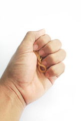 The Asian male hand is holding a gold ring on a white background.
