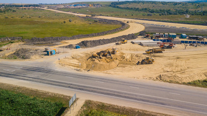 Aerial Road Building Site. Flight Over Construction Crews And Heavy Equipment