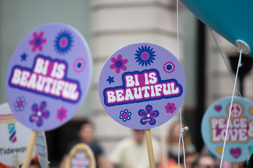 A person holding a Bi is beautiful banner at a gay pride event