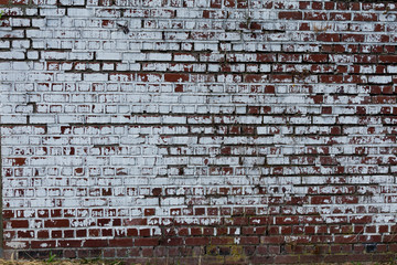 Full red brick wall with old white paint