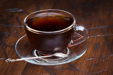 Coffee in a glass cup on a wooden background.