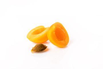 Ripe and bright apricots on a glass plate with water droplets and one apricot cut with a bone.