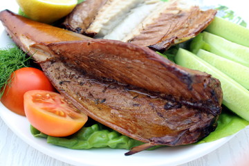 Smoked mackerel on a plate. mackerel with lemon and vegetables
