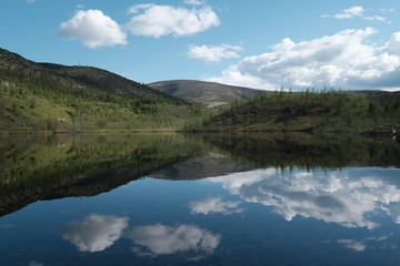 Fototapeta na wymiar Lake surrounded by low mountains