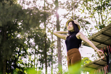 Portrait of asian women relax with green nature, Rest on vacation with nature forest, Smilling and chilling girl, Asian girl stand against green forest with flare sun light