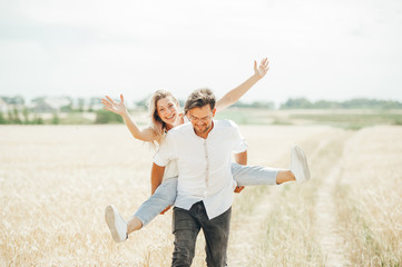 Happy young couple enjoying in the wheat field.