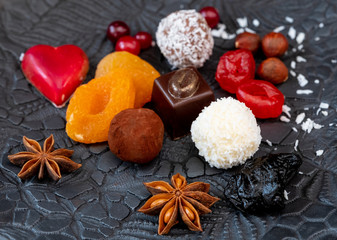Truffles and dried fruits on a black clay plate