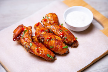 BBQ chicken wings with sauce on paper. Close-up, selective focus.