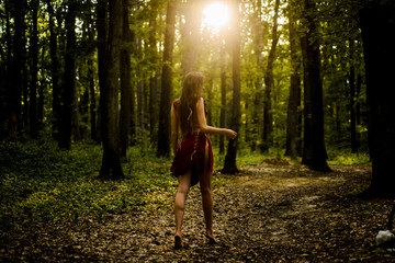 amazon woman. sexy witch. sexy girl in leather suede clothes. ethnic tribal fashion. deep forest. cougar female. wild woman in forest. female silhouette through the sun rays. Sexy young female - Powered by Adobe