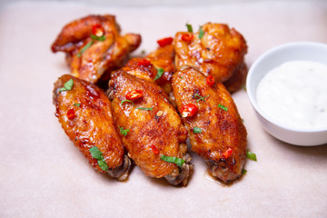 BBQ chicken wings with sauce on paper. Close-up, selective focus.