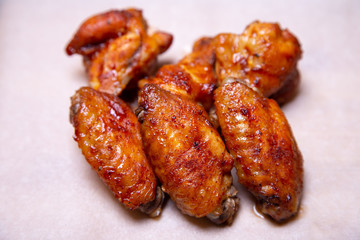 BBQ chicken wings on paper. Close-up, selective focus.